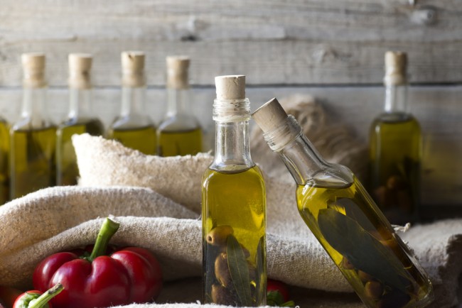 olives and olive oil in mini bottle on wood table